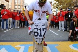 Jonny Gomes brings the 2013 World Series Championship Trophy to the finish line of the Boston Marathon.